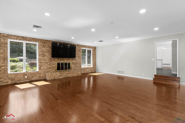 3408 Airline Rd, Longview, TX 75605 - unfurnished living room with wood finished floors, recessed lighting, a brick fireplace, and ornamental molding