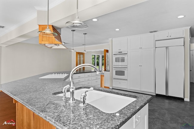 3408 Airline Rd, Longview, TX 75605 - kitchen with white double oven, paneled fridge, crown molding, a large island with sink, and white cabinets