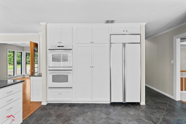 3408 Airline Rd, Longview, TX 75605 - kitchen featuring paneled refrigerator, white double oven, ornamental molding, white cabinets, and dark stone countertops