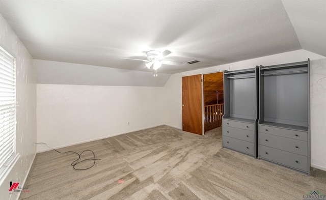 unfurnished bedroom featuring ceiling fan, light colored carpet, and lofted ceiling