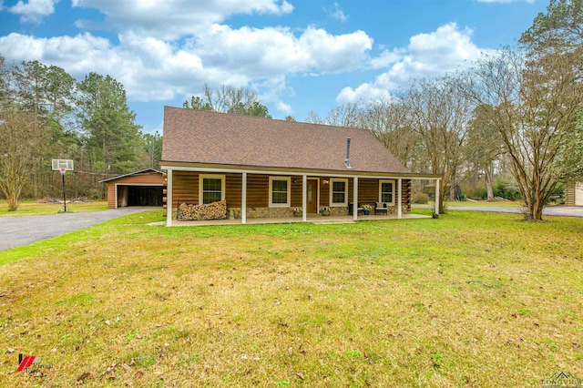 log cabin featuring covered porch, a front lawn, and a carport