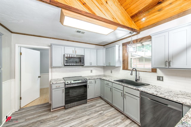 kitchen with lofted ceiling, sink, pendant lighting, light hardwood / wood-style floors, and stainless steel appliances