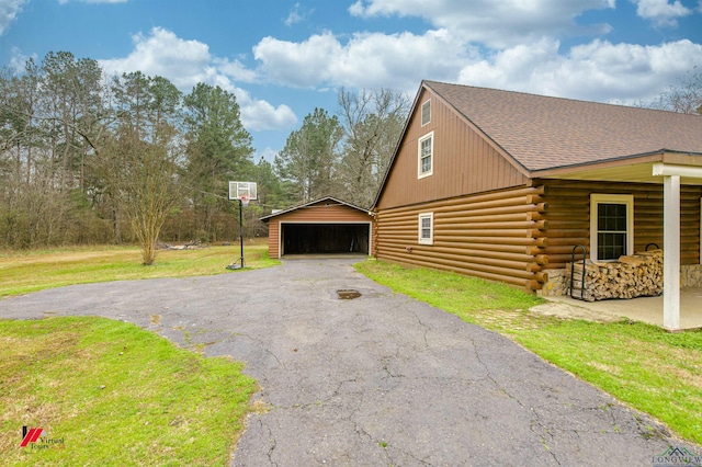 view of home's exterior featuring a garage, an outdoor structure, and a yard