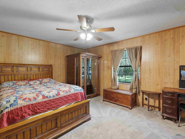 carpeted bedroom featuring ceiling fan, wooden walls, and a textured ceiling