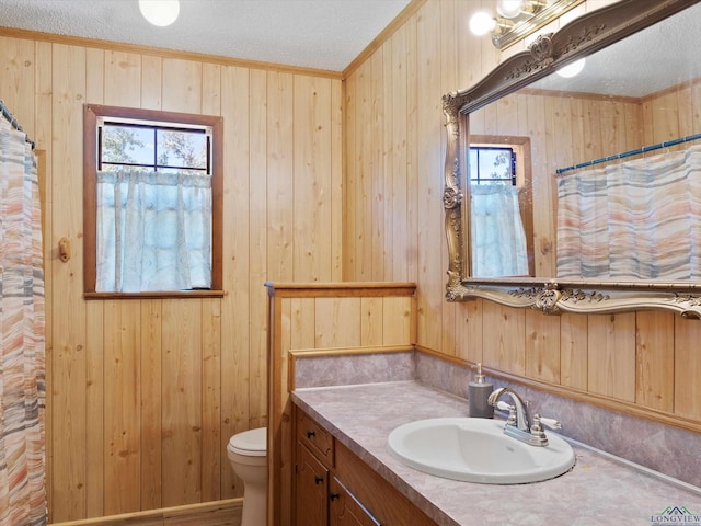 bathroom featuring a textured ceiling and wood walls