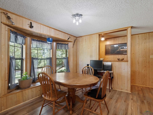 dining space with hardwood / wood-style flooring and wood walls