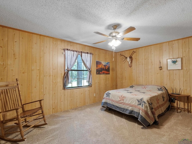 carpeted bedroom with a textured ceiling, ceiling fan, and wood walls