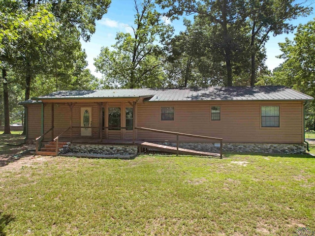 rear view of house with covered porch and a yard