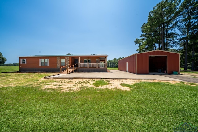 rear view of property featuring a lawn, an outbuilding, a porch, and a garage