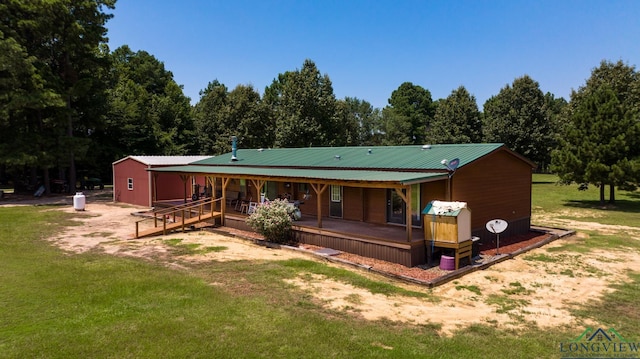 rear view of house with a porch and a yard