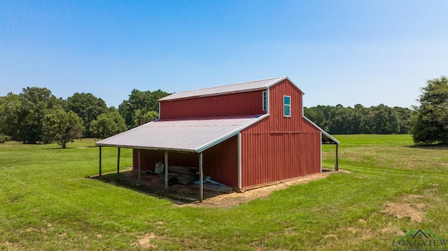 view of outbuilding with a lawn and a rural view