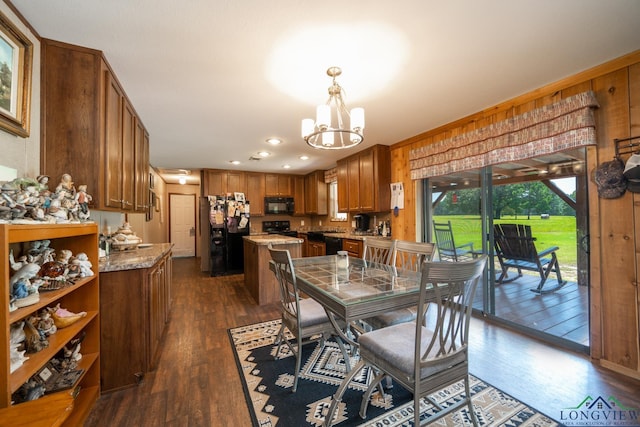 dining area featuring dark hardwood / wood-style flooring and an inviting chandelier