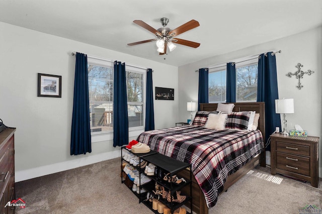 bedroom featuring light carpet, baseboards, and a ceiling fan