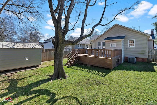 view of yard featuring an outbuilding, a storage shed, fence, cooling unit, and a wooden deck