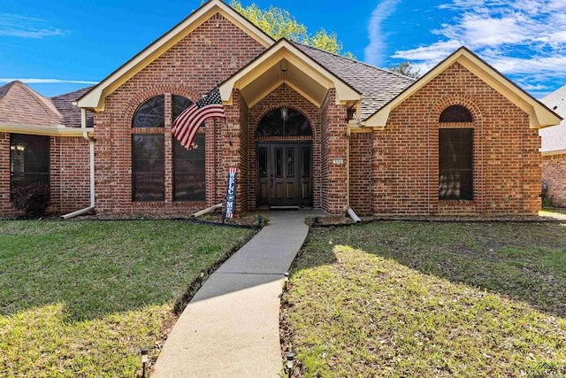504 Lakewood Dr, Longview, TX 75604 - ranch-style house with brick siding, a front yard, and a shingled roof