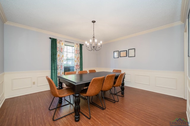 dining space with dark hardwood / wood-style floors, an inviting chandelier, and ornamental molding