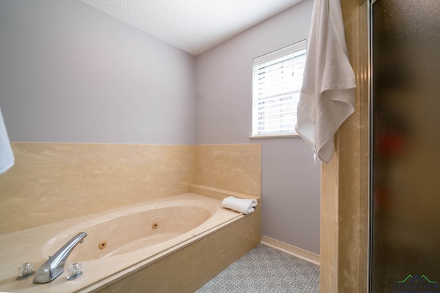 bathroom with tile patterned flooring, a textured ceiling, and a bathing tub