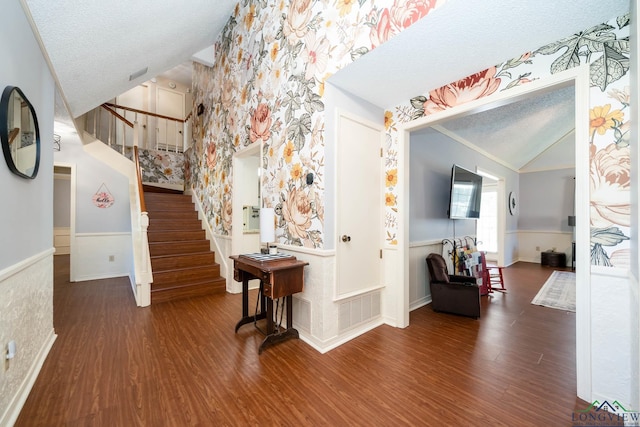 interior space with a textured ceiling, high vaulted ceiling, crown molding, and dark wood-type flooring