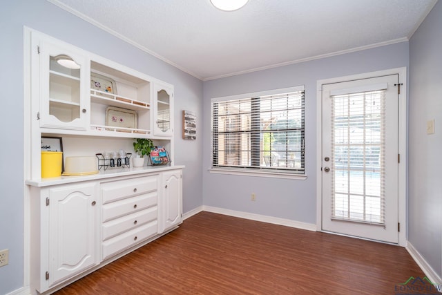 bar featuring a textured ceiling, dark hardwood / wood-style flooring, white cabinetry, and crown molding