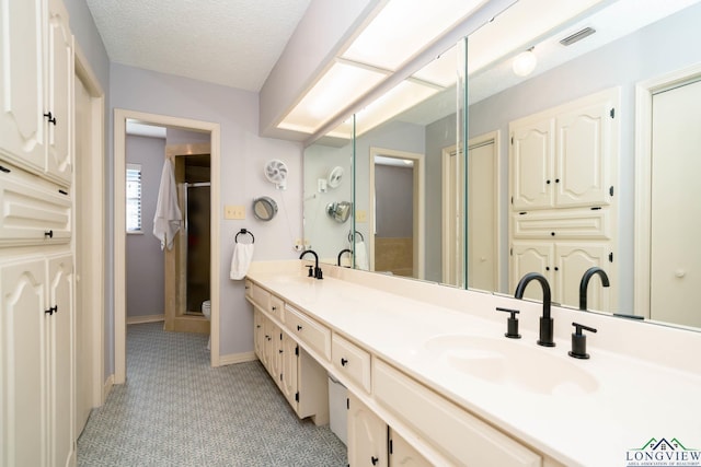 bathroom featuring vanity, a textured ceiling, and walk in shower