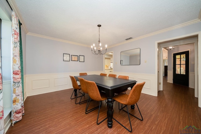 dining area with a notable chandelier, dark hardwood / wood-style flooring, ornamental molding, and a textured ceiling