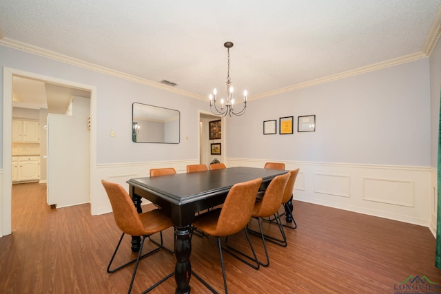 dining area featuring a notable chandelier, wood-type flooring, and ornamental molding