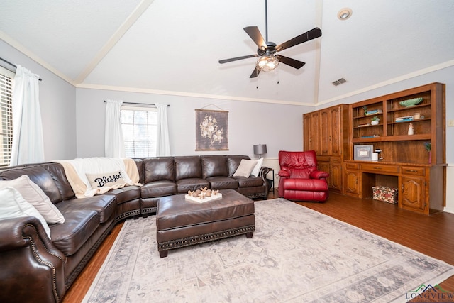 living room featuring hardwood / wood-style floors, lofted ceiling, and ornamental molding