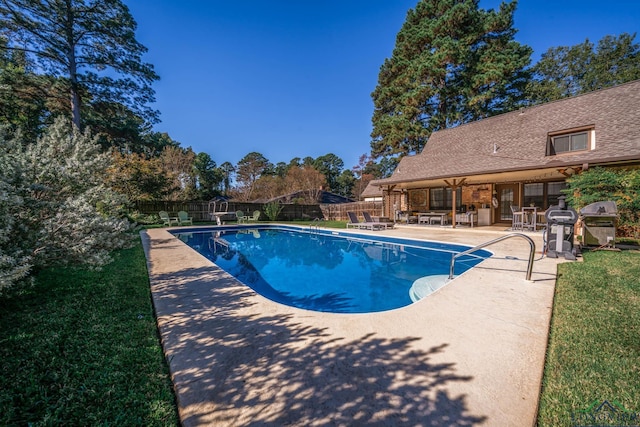 view of swimming pool with a lawn, area for grilling, and a patio area