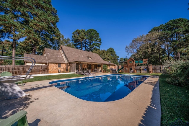 view of pool with a playground and a patio