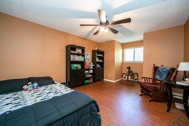 bedroom featuring ceiling fan, dark hardwood / wood-style floors, and a textured ceiling