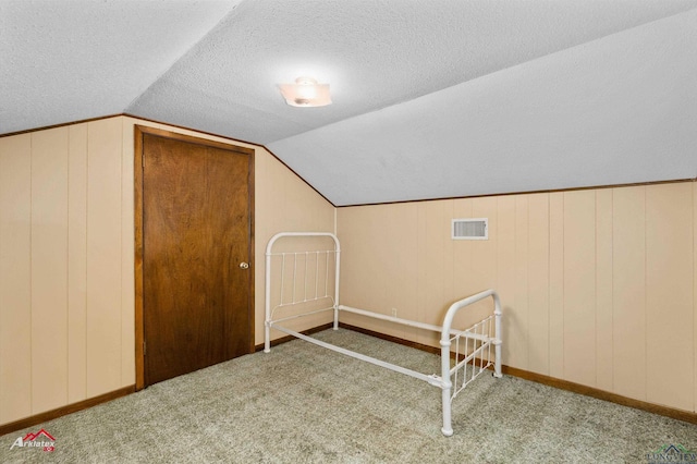 additional living space with a textured ceiling, carpet floors, and lofted ceiling