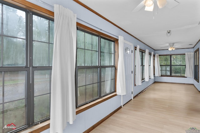 unfurnished sunroom featuring ceiling fan