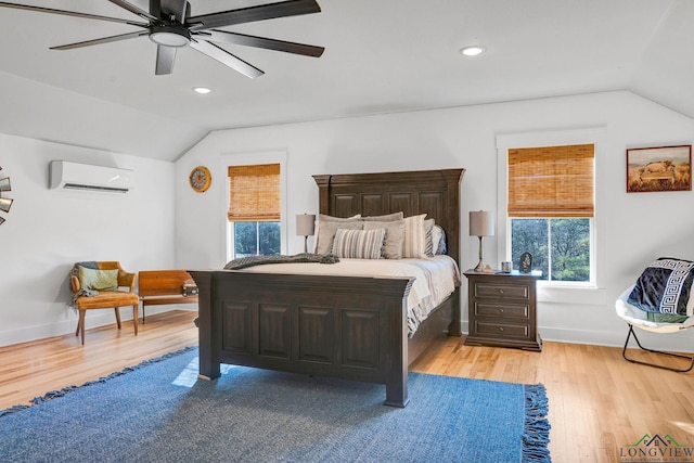 bedroom with ceiling fan, light hardwood / wood-style flooring, a wall mounted air conditioner, and lofted ceiling