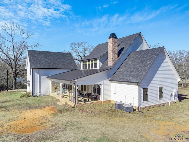 rear view of property featuring a patio area, a yard, and central AC