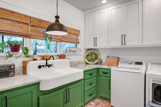 washroom featuring sink, cabinets, and washer and clothes dryer