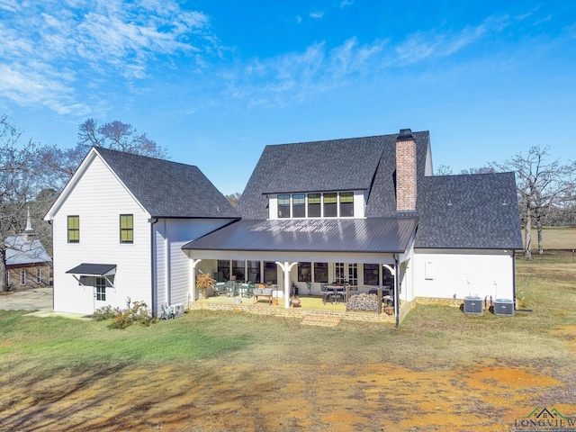 rear view of property with a patio, a yard, and central AC unit