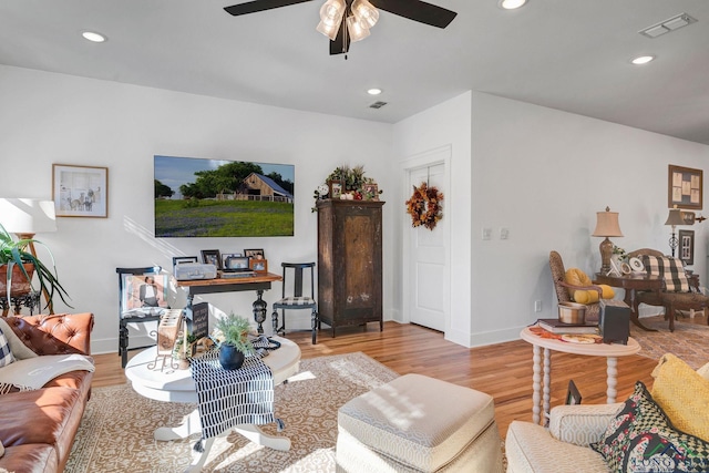 living room with ceiling fan and light hardwood / wood-style flooring