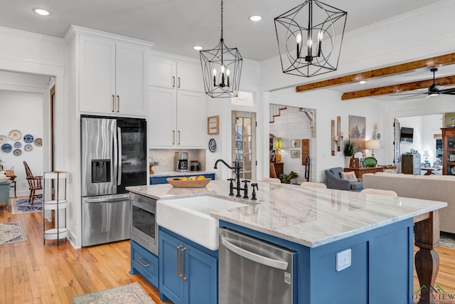 kitchen with stainless steel appliances, ceiling fan, beam ceiling, white cabinetry, and blue cabinets