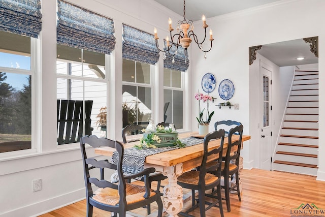 dining room featuring an inviting chandelier, ornamental molding, and hardwood / wood-style floors