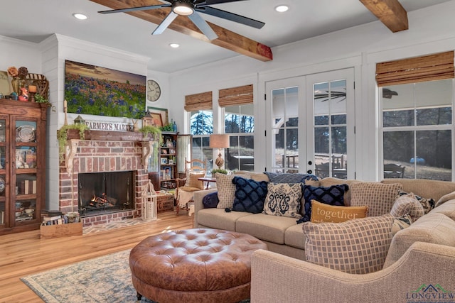 living room featuring a fireplace, beamed ceiling, french doors, hardwood / wood-style flooring, and crown molding