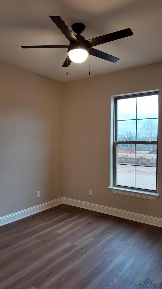 empty room with ceiling fan, dark wood-type flooring, and baseboards