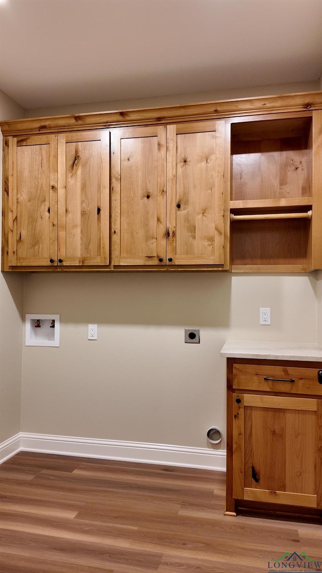 washroom featuring washer hookup, wood finished floors, baseboards, cabinet space, and electric dryer hookup