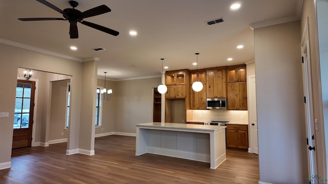 kitchen featuring visible vents, backsplash, dark wood-style floors, stainless steel microwave, and crown molding