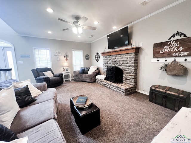 living room featuring carpet, ceiling fan, crown molding, and a brick fireplace