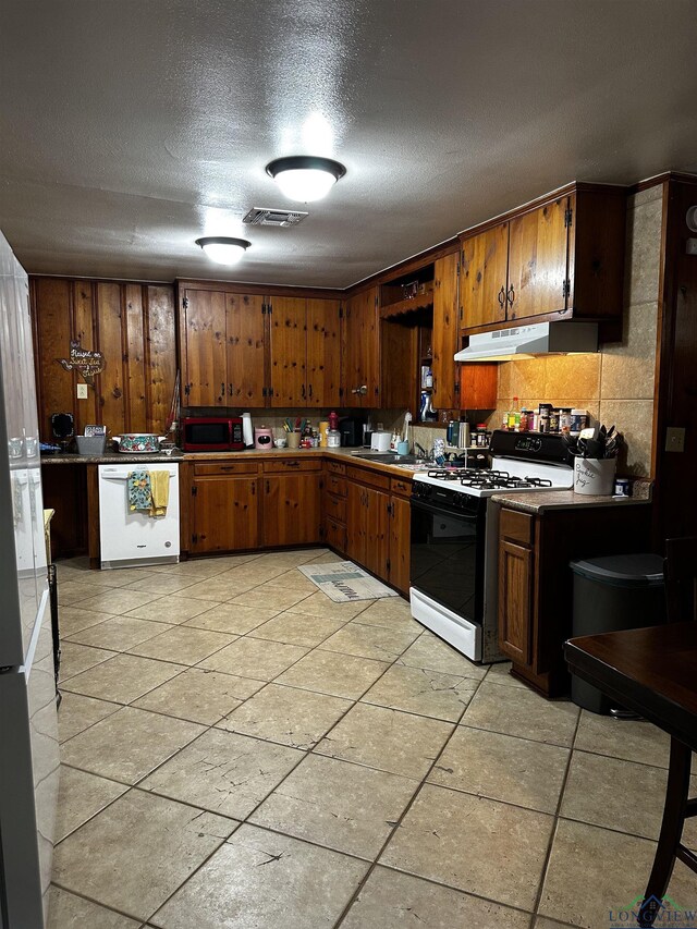 dining room featuring wooden walls, visible vents, and ceiling fan