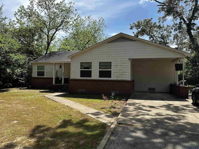 view of front of home featuring driveway, brick siding, a front yard, and an attached carport