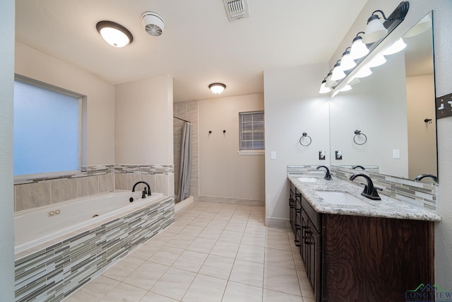 bathroom featuring tile patterned flooring, shower with separate bathtub, and vanity