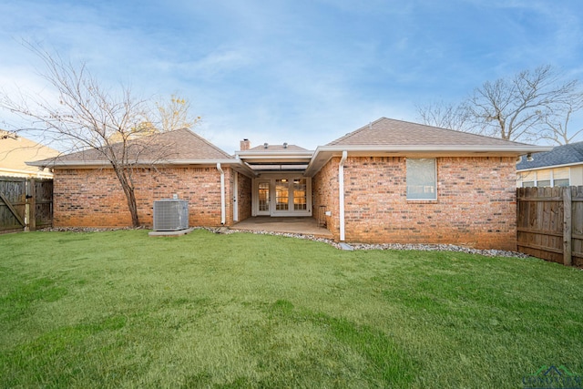 rear view of house featuring a patio, a lawn, and central air condition unit