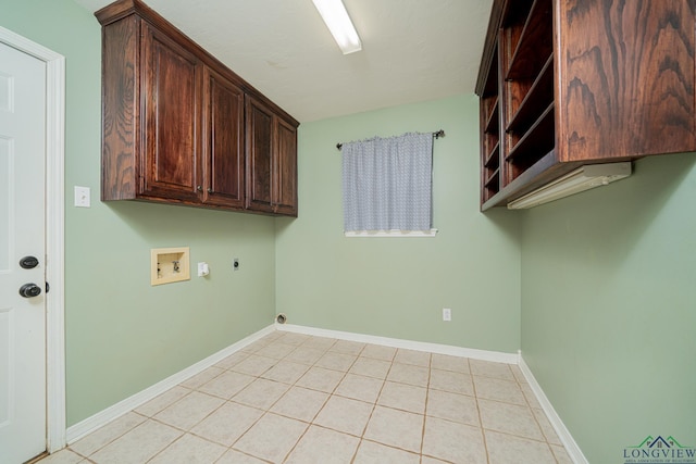 washroom with washer hookup, electric dryer hookup, light tile patterned floors, and cabinets