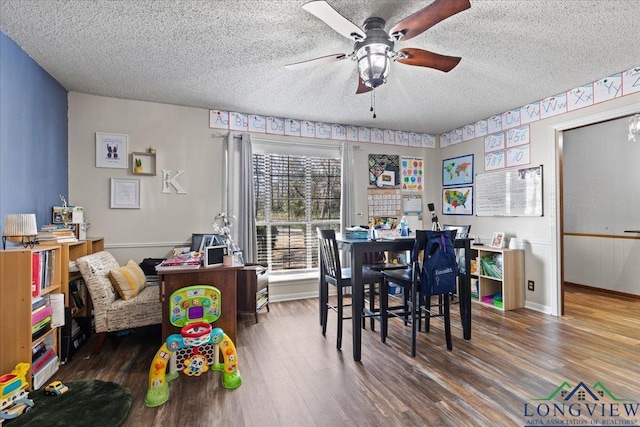 dining area featuring ceiling fan, a textured ceiling, and wood finished floors